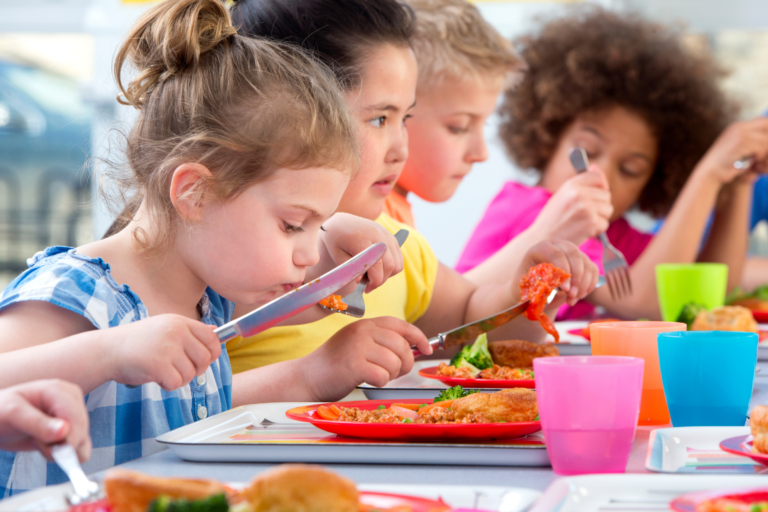 Children eating a healthy meal at nursery.